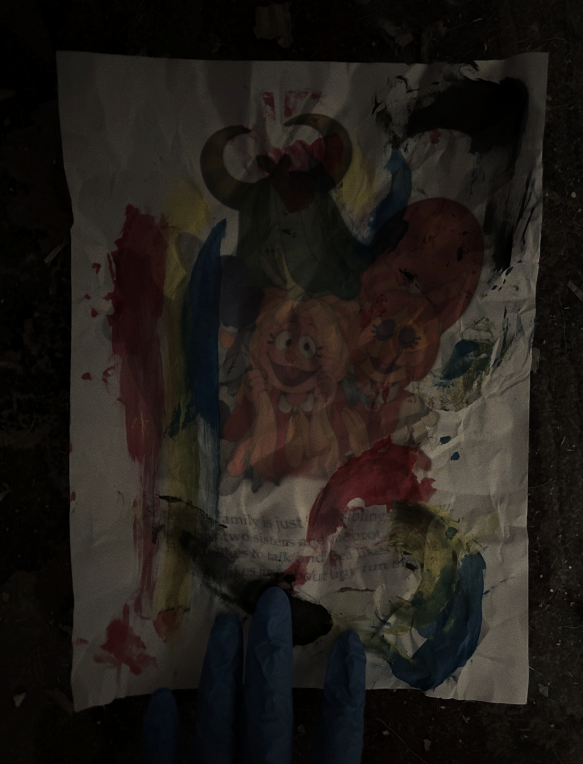 A photograph a dirty piece of paper. It has smeared ink among other things on it. Barely visible is what was originally on the paper: an illustration of Julie Joyful and her siblings.