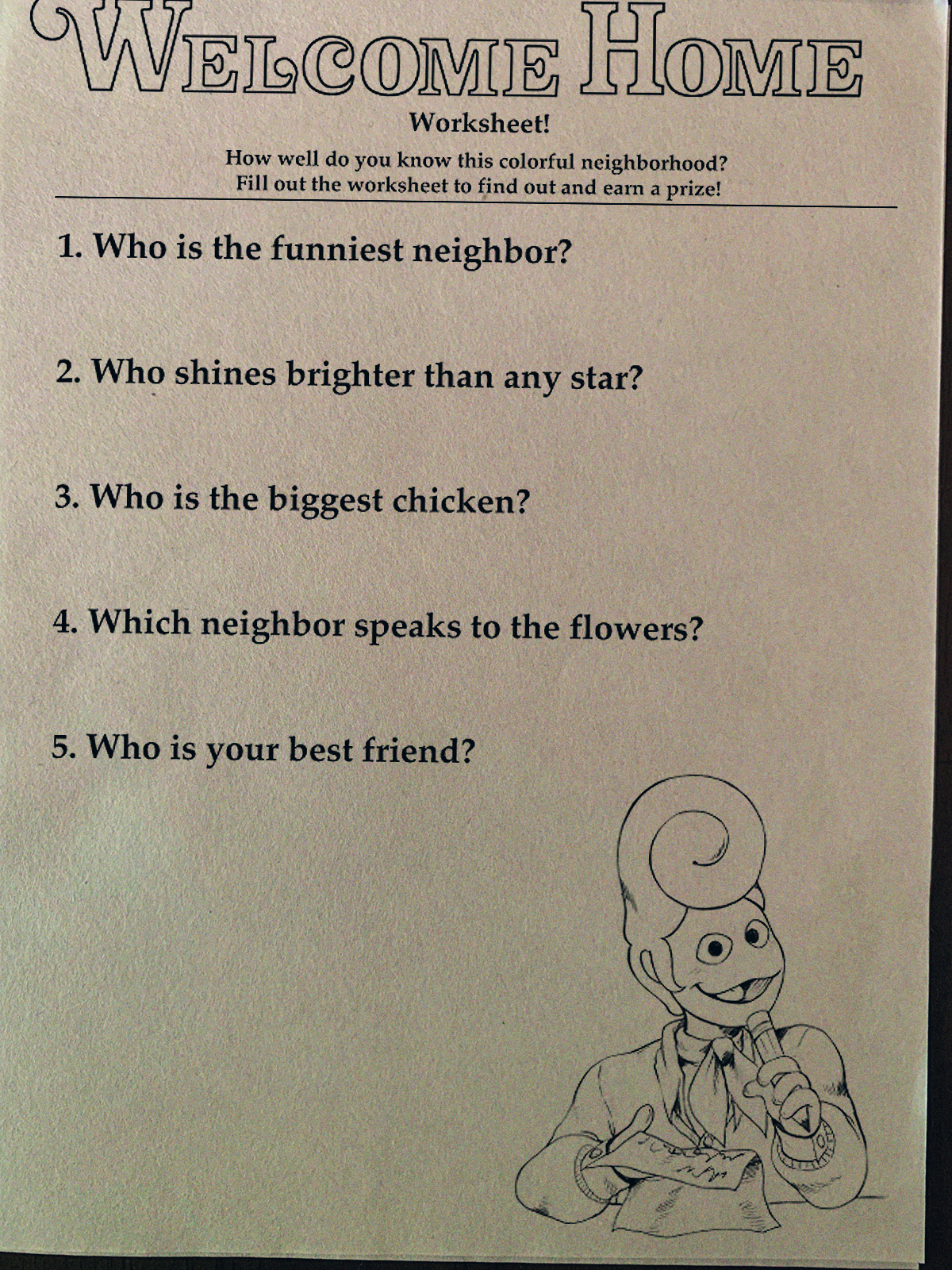 A photograph of a 'Welcome Home Worksheet!' it continues: 'How well do you know this colorful neighborhood? Fill out the worksheet to find out and earn a prize! 1. Who is the funniest neighbor? 2. Who shines brighter than any star? 3. Who is the biggest chicken? 4. Which neighbor speaks to the flowers? 5. Who is your best friend?' At the bottom right is an illustration of Wally looking towards us, a sheet of paper and pencil in hand.